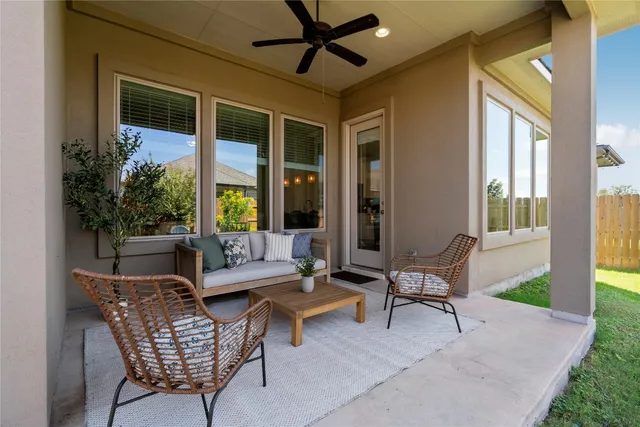 a view of a patio with table and chairs potted plants and large tree