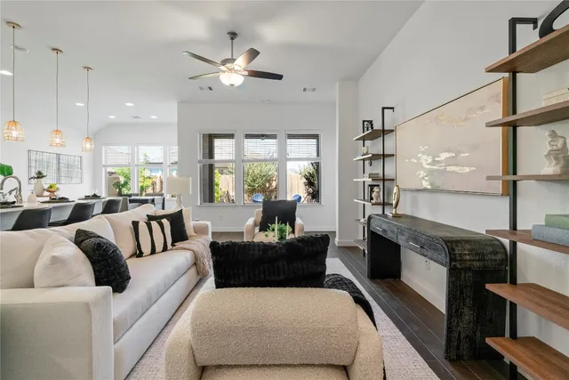 a living room with furniture kitchen view and a chandelier