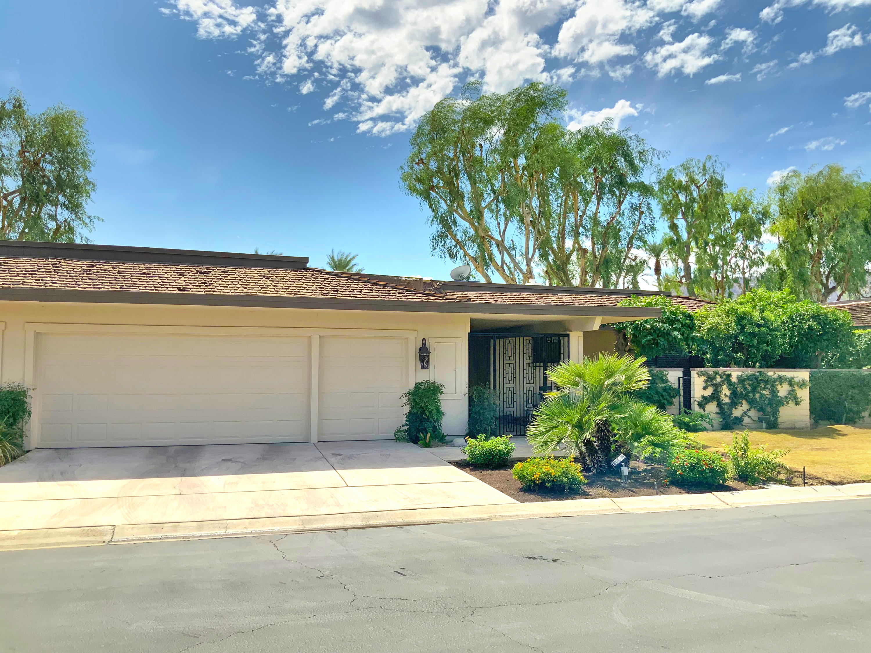 7 Princeton Drive Rancho Mirage, CA 92270 - Photo 5 of 39 a front view of a house with a yard and trees