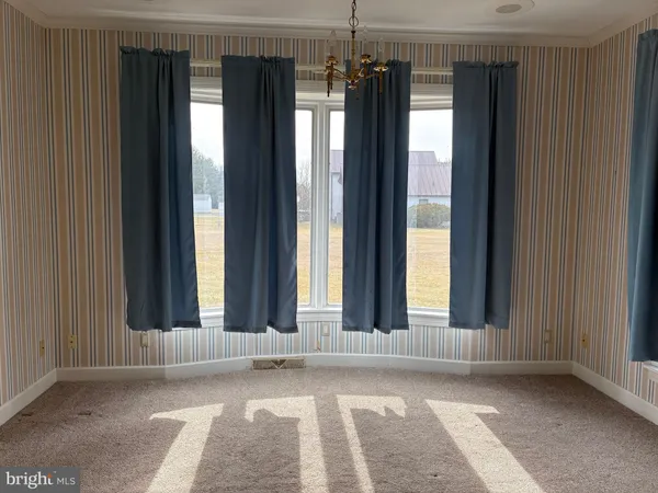 an empty room with windows and a chandelier