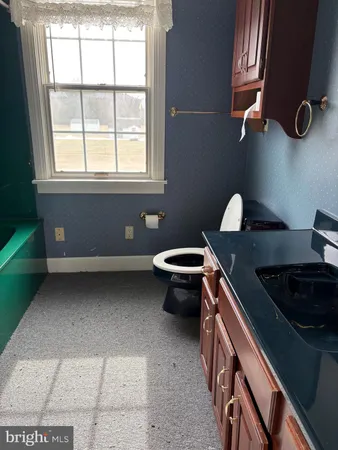 a bathroom with a toilet sink and mirror