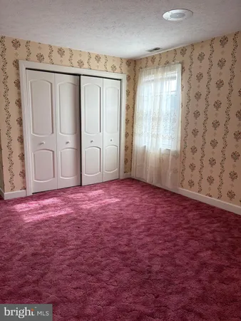 an empty room with windows and closet