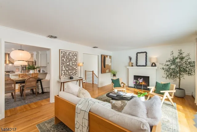 a living room with furniture and a dining table with kitchen view