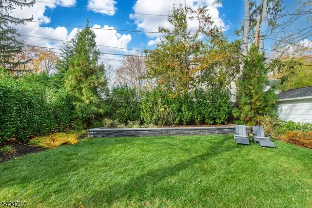 a backyard of a house with garden and outdoor seating