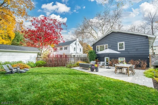 a front view of a house with backyard garden and outdoor seating