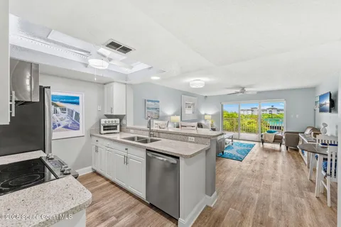 a kitchen with stainless steel appliances a stove a sink dishwasher and cabinets with wooden floor