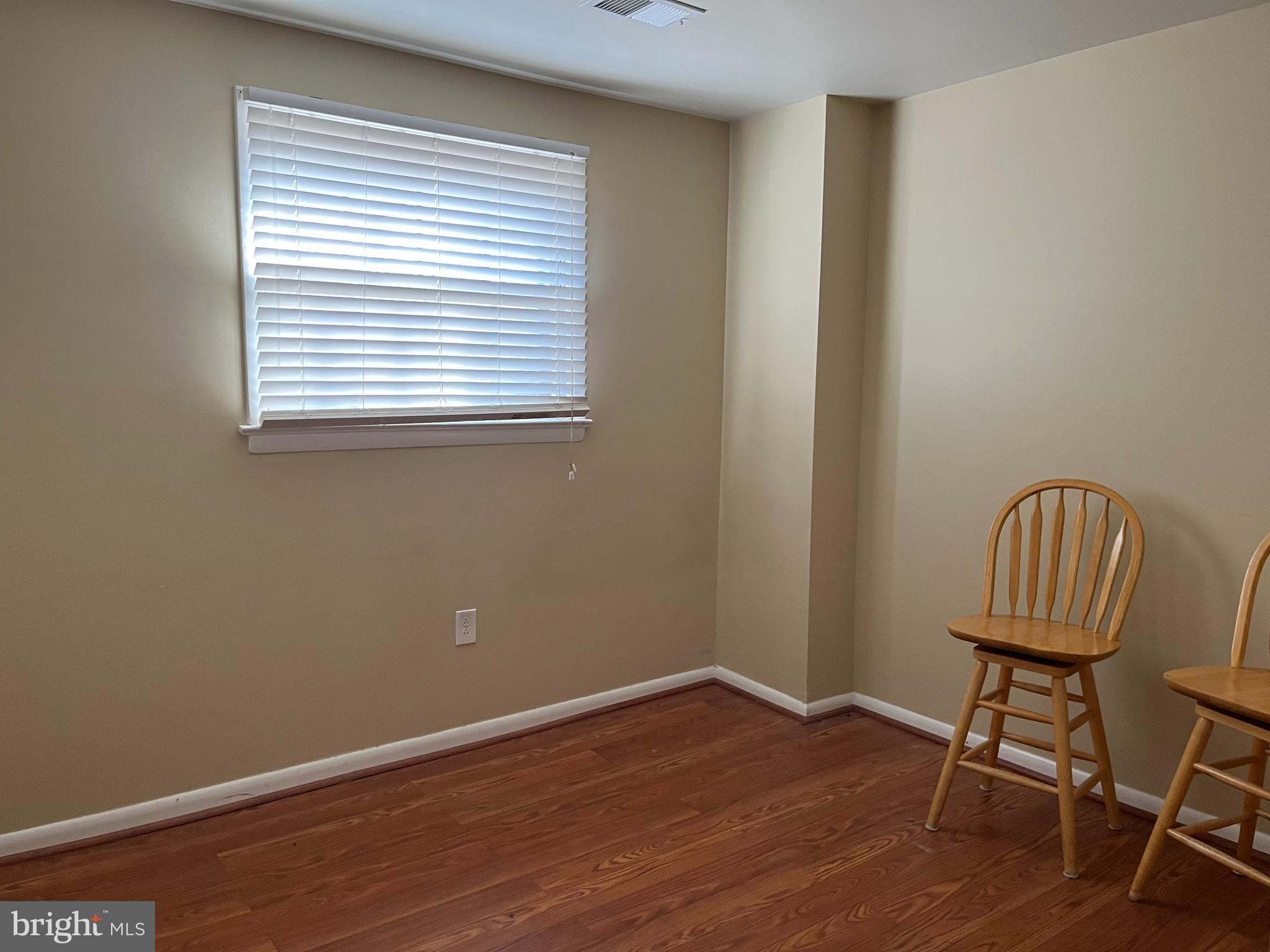 7018 Redmiles Road Laurel, MD 20707 - Photo 30 of 39 a view of a room with wooden floor a chair and a window