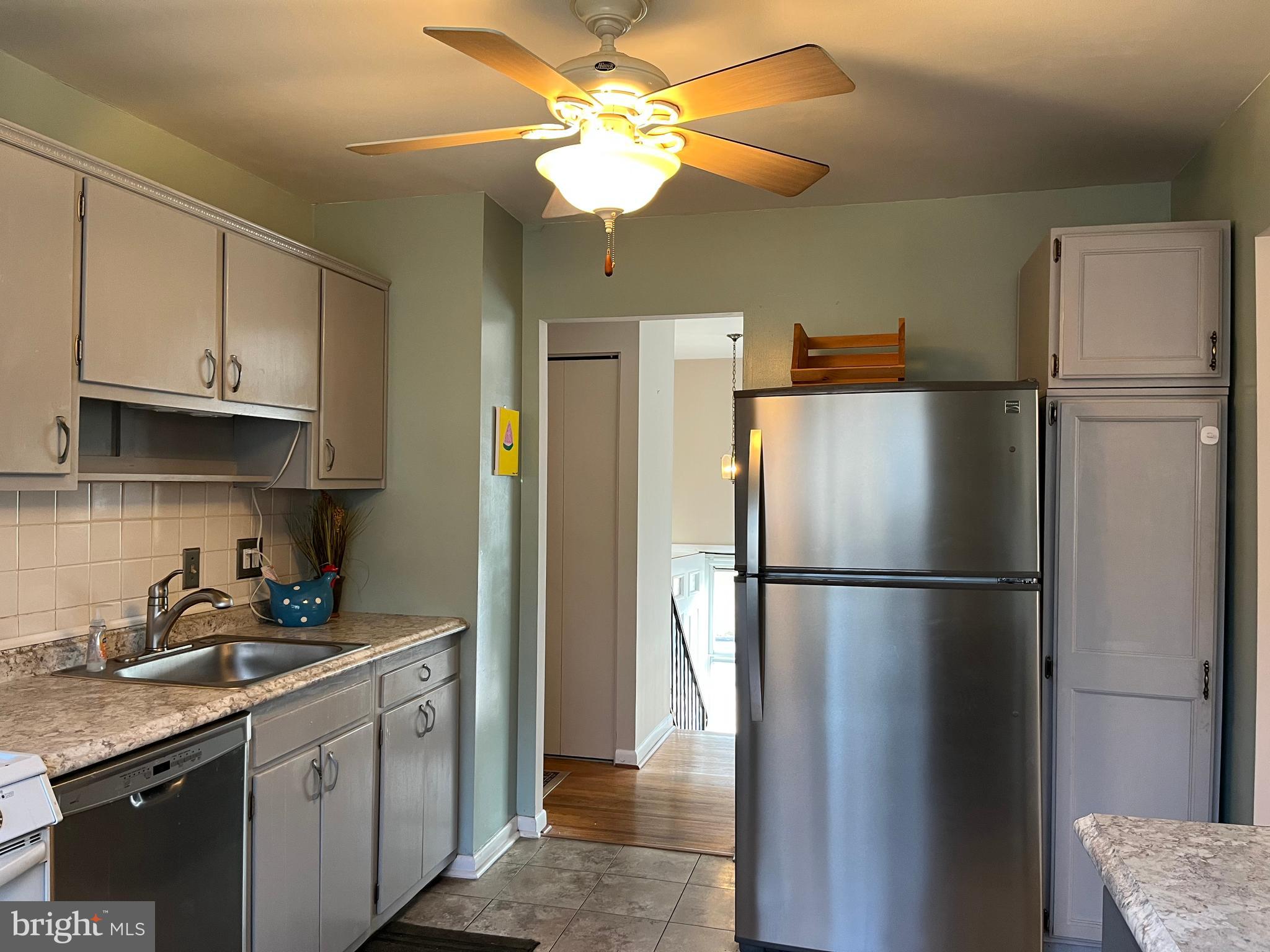 7018 Redmiles Road Laurel, MD 20707 - Photo 5 of 39 a kitchen with stainless steel appliances granite countertop a refrigerator a sink a stove and white cabinets