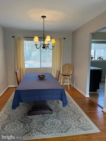 a room with table chairs and wooden floor