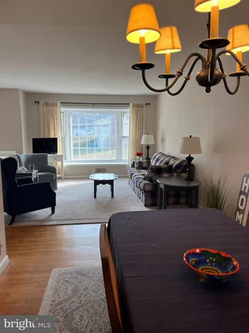 a living room with furniture a chandelier and a flat screen tv