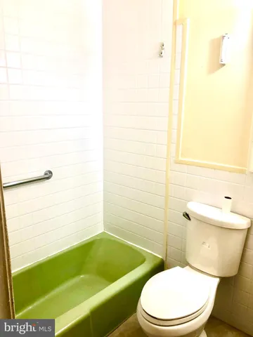 a white toilet and tub sitting next to a bathroom sink