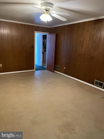 an empty room with a chandelier fan
