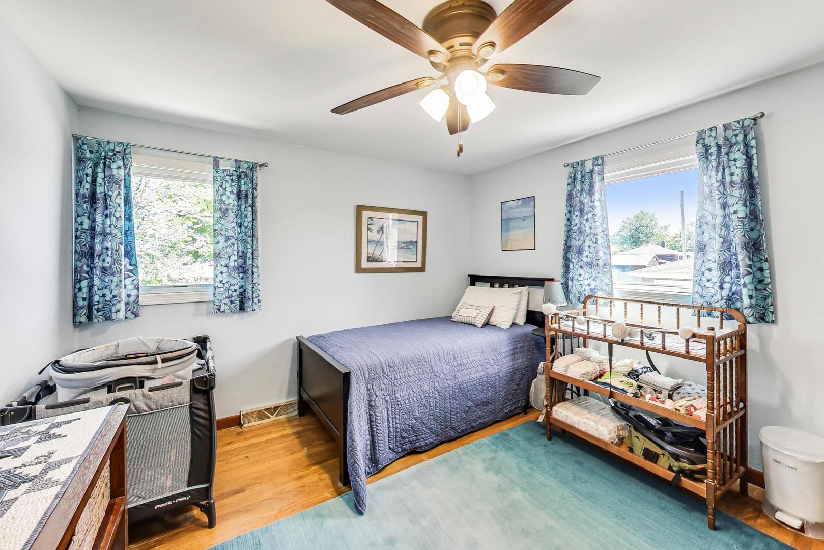 10729 Rutherford Avenue Worth, IL 60482 - Photo 14 of 22 a bedroom with a bed and a chandelier