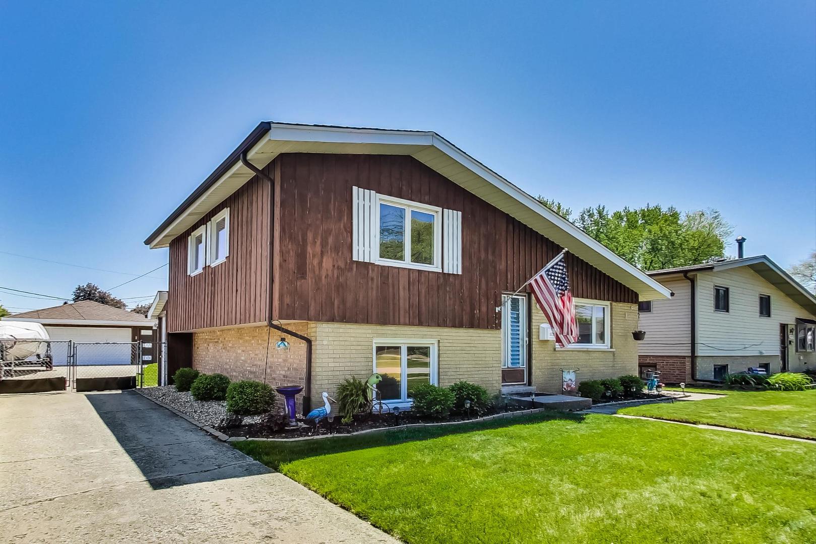 10729 Rutherford Avenue Worth, IL 60482 - Photo 2 of 22 a front view of a house with a yard and trees