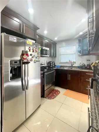 a kitchen with stainless steel appliances granite countertop a sink a stove and refrigerator
