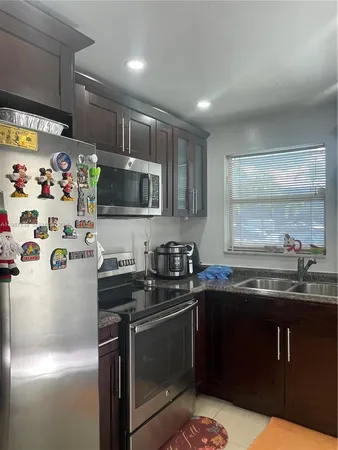 a kitchen with granite countertop a sink and stainless steel appliances