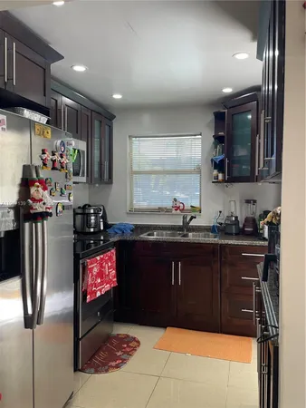 a kitchen with stainless steel appliances granite countertop a refrigerator and a sink