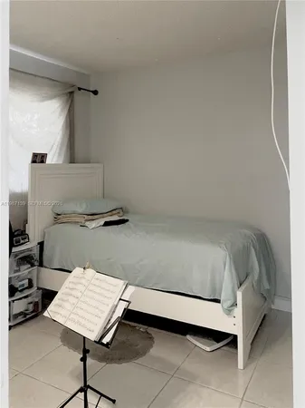 a bed sitting in a bedroom next to a window