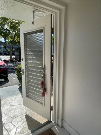 a view of a porch with a door and a car parked in front of it