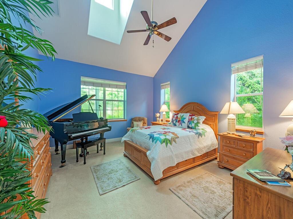 21950 North River Road Alva, FL 33920 - Photo 10 of 28 Bedroom with high vaulted ceiling, light colored carpet, and a ceiling fan