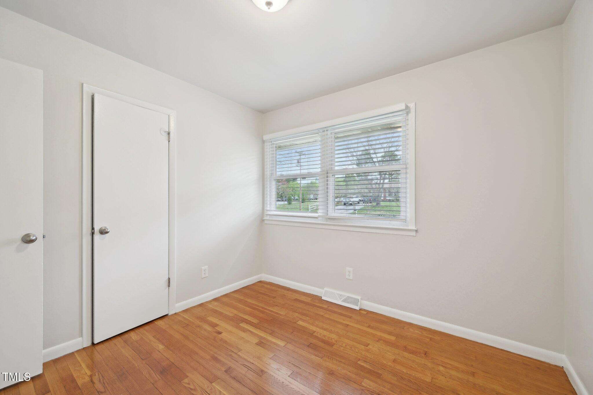 5218 Revere Road Durham, NC 27713 - Photo 18 of 46 a view of an empty room with wooden floor and a window
