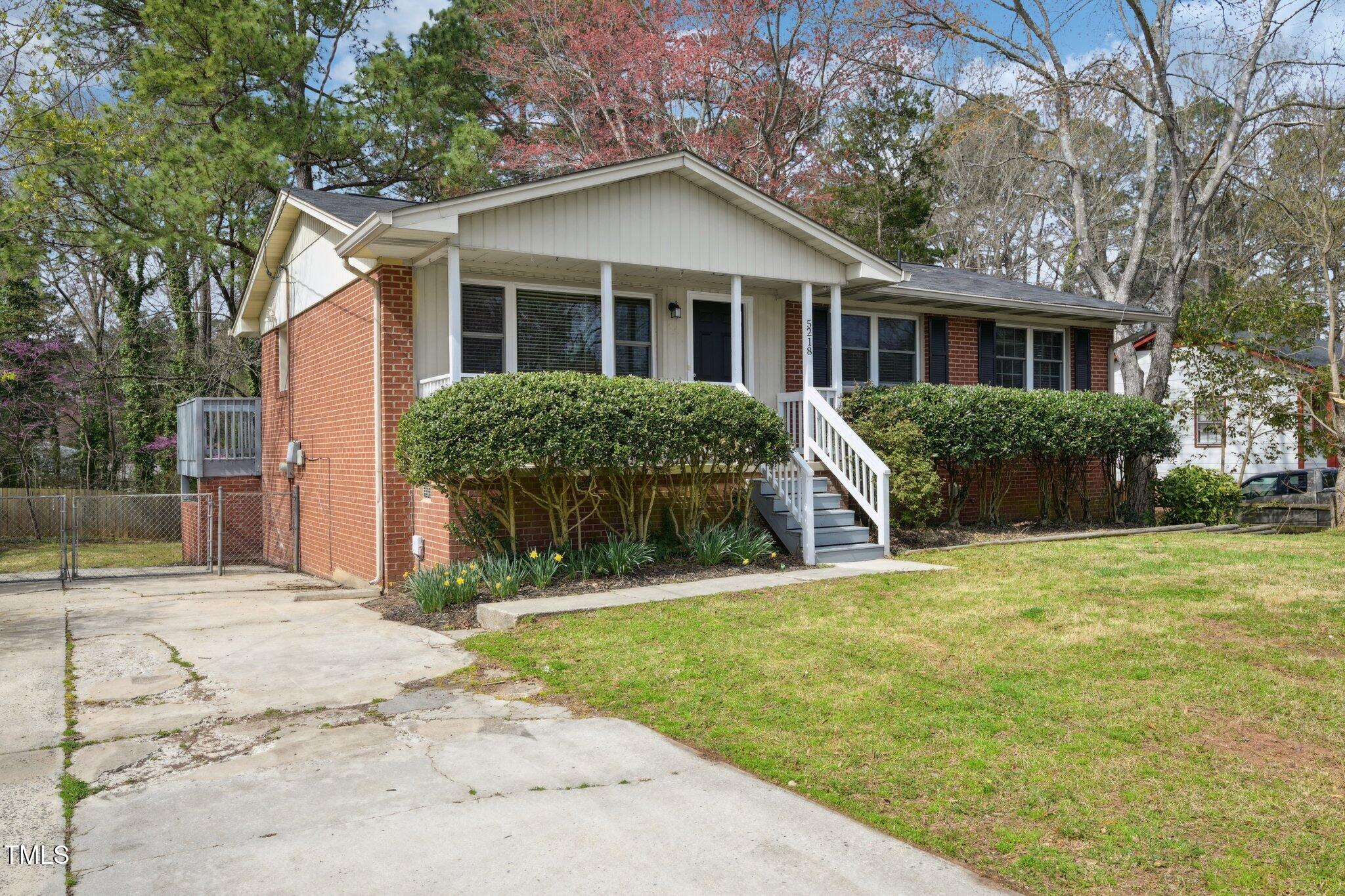 5218 Revere Road Durham, NC 27713 - Photo 2 of 46 a front view of a house with a yard and potted plants