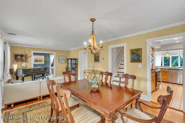 a dining room with furniture a chandelier and wooden floor
