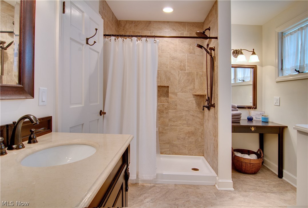 469 Overwood Road Akron, OH 44313 - Photo 12 of 18 Stunning bathroom renovation with neutral tones, rich woodwork, and matching distressed brass fixtures.