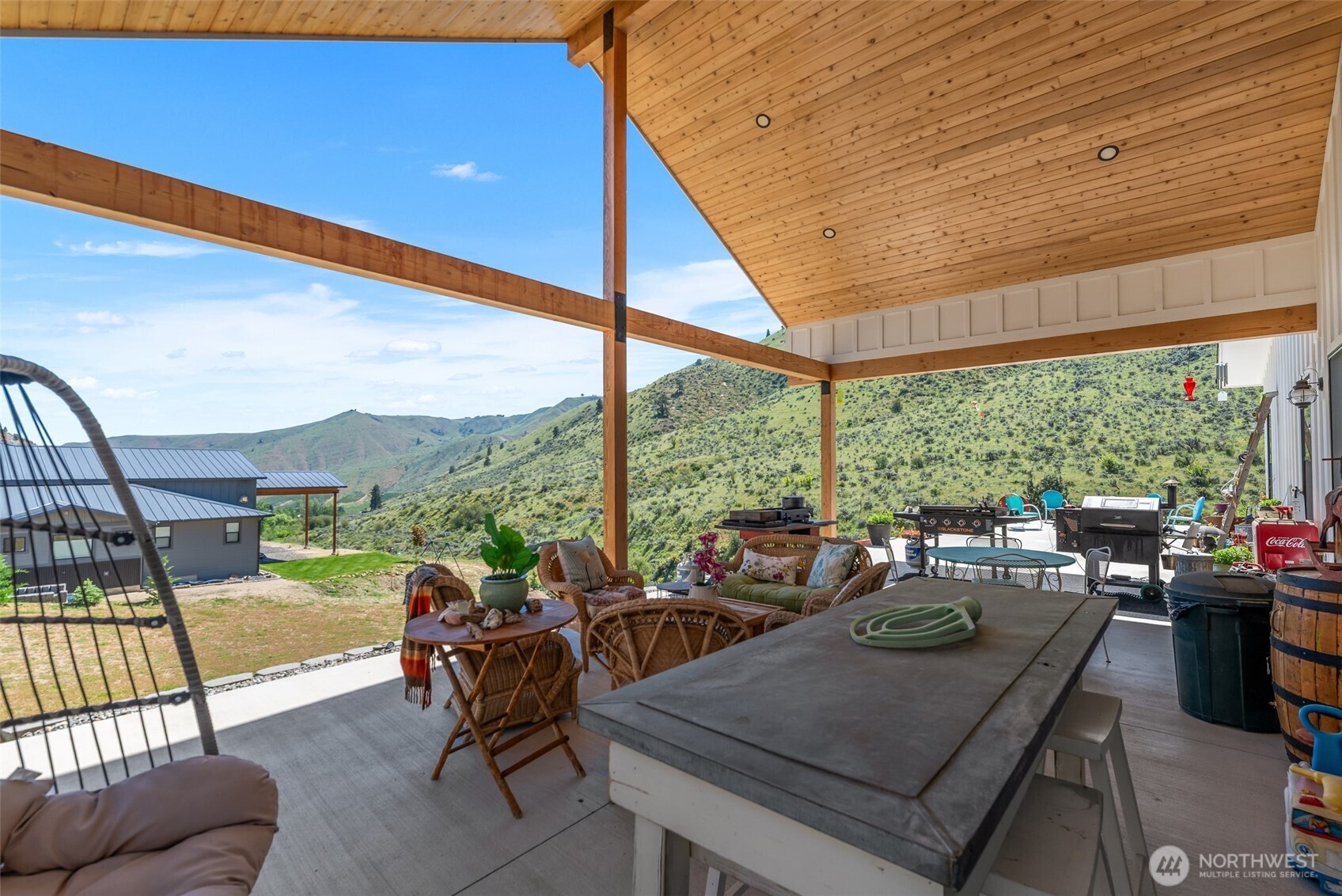 1541 Pitcher Canyon Road Wenatchee, WA 98801 - Photo 37 of 40 a view of a patio with couches chairs dining table and chairs barbeque grill with a small yard and large trees