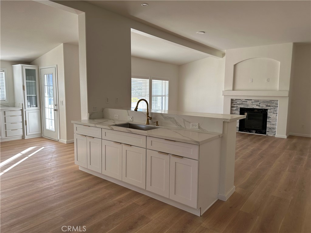 21204 Versaie Perris, CA 92570 - Photo 12 of 33 a kitchen with granite countertop a stove top oven a sink and dishwasher with wooden floor