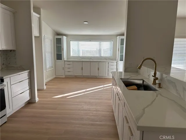 a kitchen with white cabinets and appliances