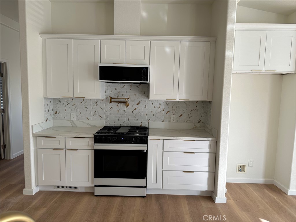 21204 Versaie Perris, CA 92570 - Photo 14 of 33 a kitchen with white cabinets and appliances