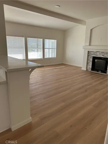 a view of an empty room with a fireplace and a window