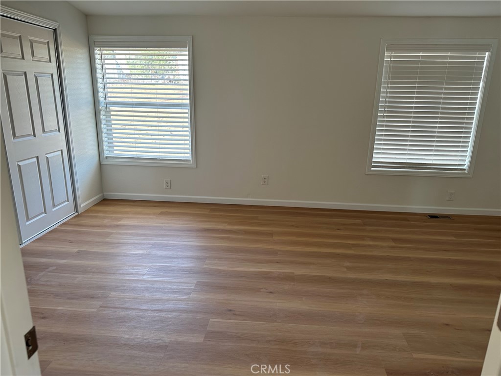 21204 Versaie Perris, CA 92570 - Photo 8 of 33 a view of an empty room with wooden floor and a window