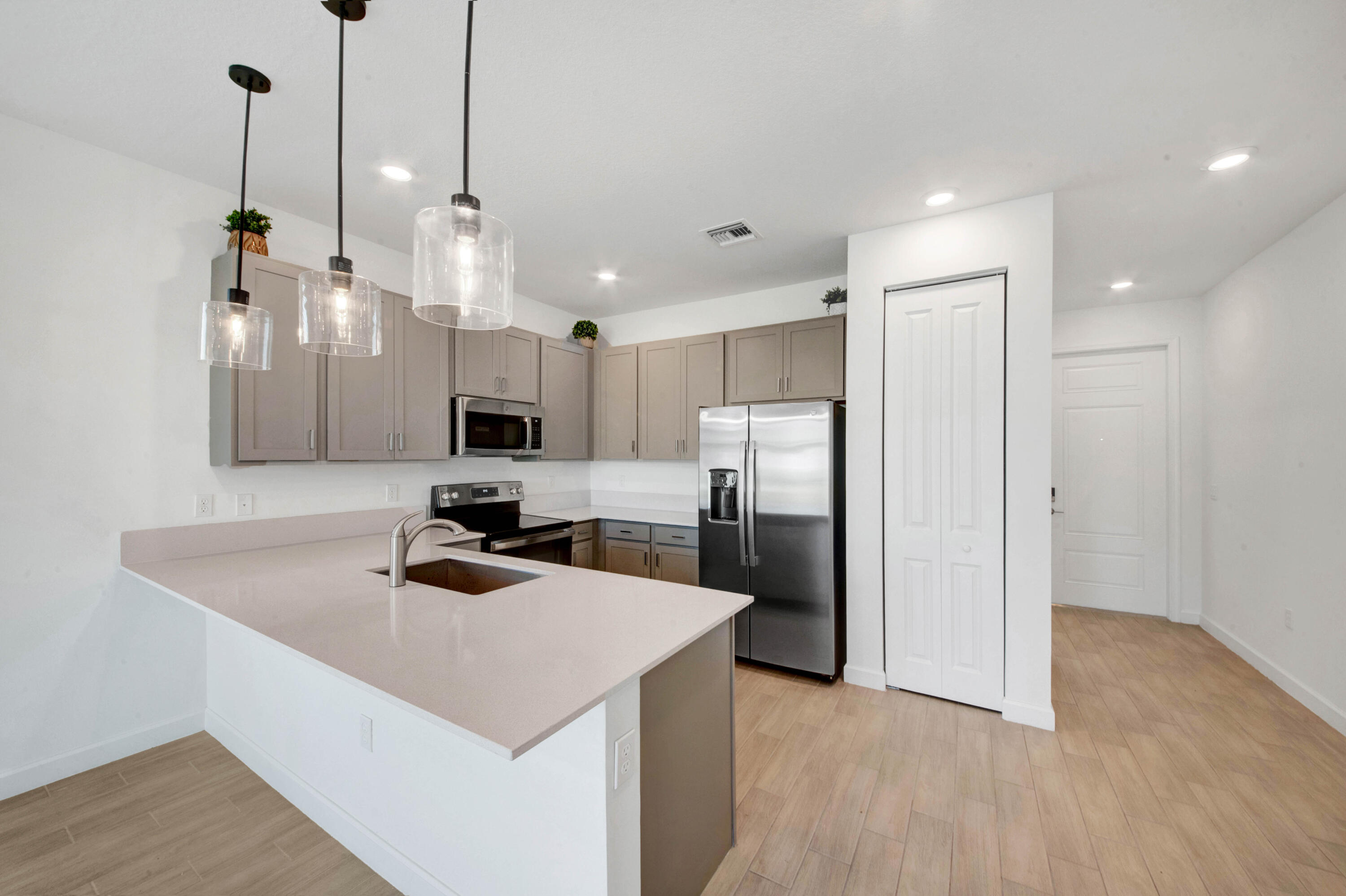 14511 Three Ponds Trail Delray Beach, FL 33446 - Photo 5 of 33 a kitchen with a refrigerator a sink and a wooden floor