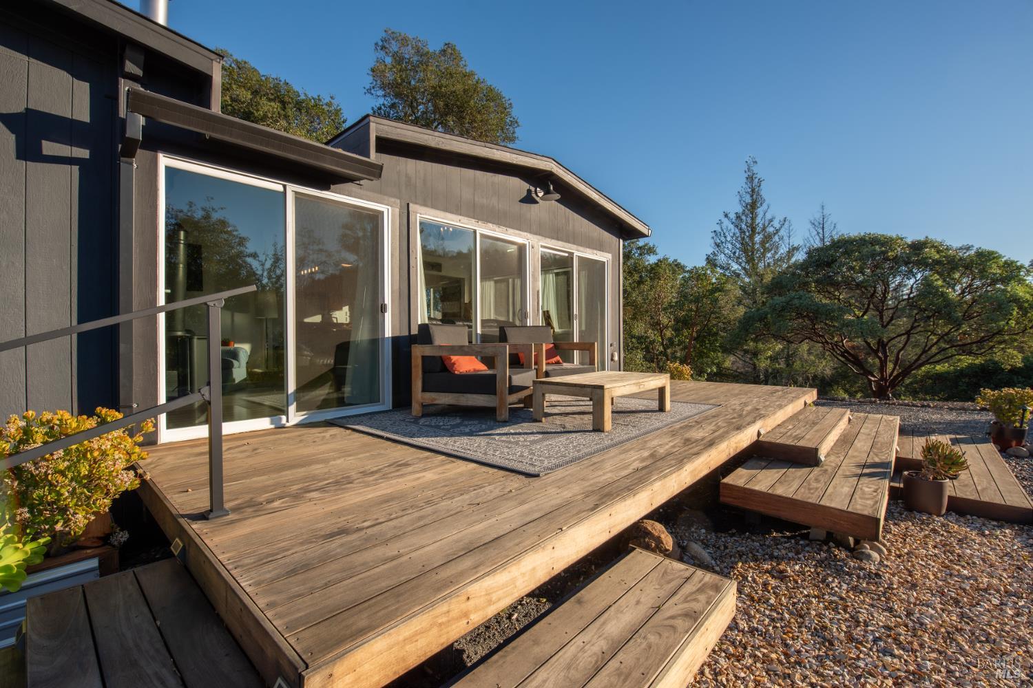 22855 Chianti Road Cloverdale, CA 95425 - Photo 62 of 76 a view of a patio with couches table and chairs with wooden floor and fence