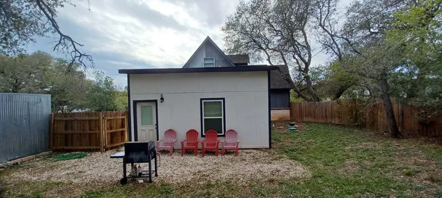 a view of backyard of house with wooden fence