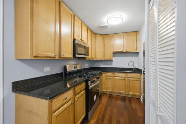 a kitchen with a refrigerator a stove top oven and cabinets