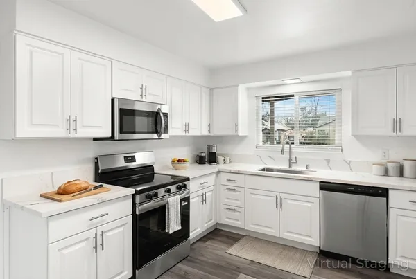 a kitchen with cabinets appliances a sink and a window