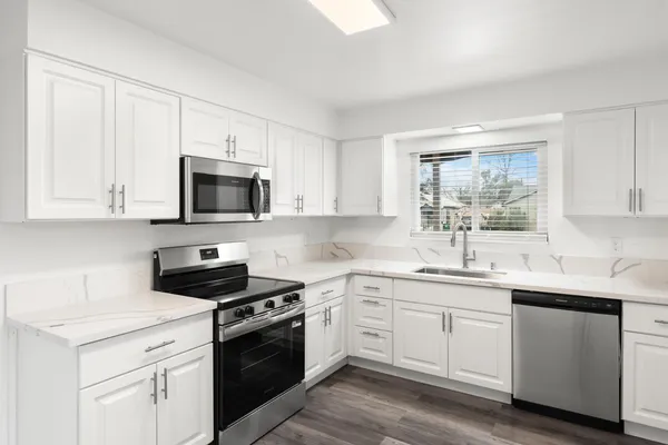 a kitchen with white cabinets stainless steel appliances and sink