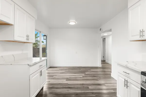 a kitchen with granite countertop white cabinets and white appliances