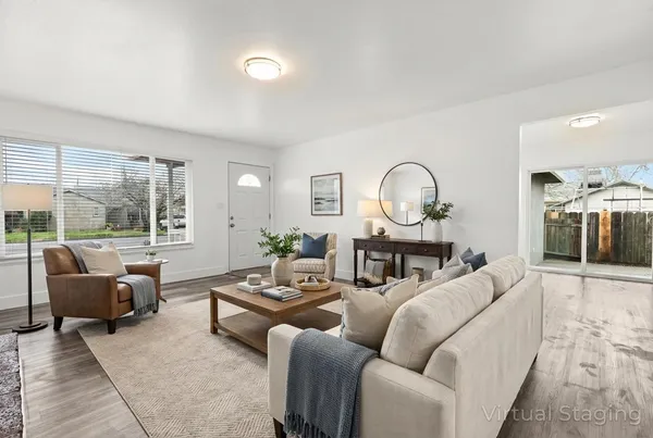 a living room with furniture a large window and a table