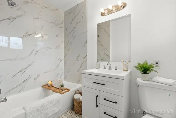 a bathroom with a granite countertop sink mirror vanity and toilet