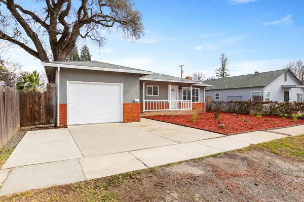 a front view of a house with a yard and potted plants