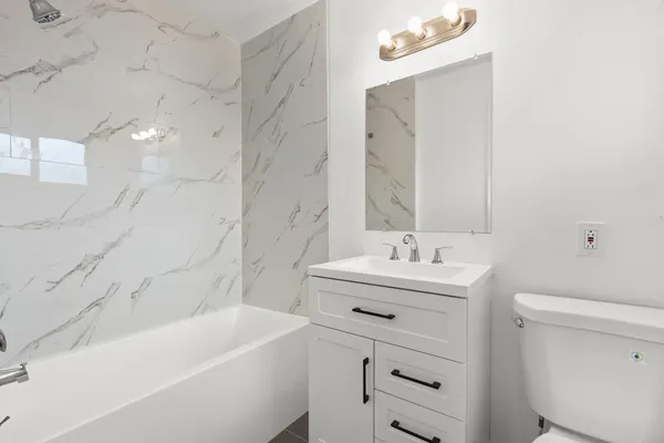 a bathroom with a sink a toilet and shower