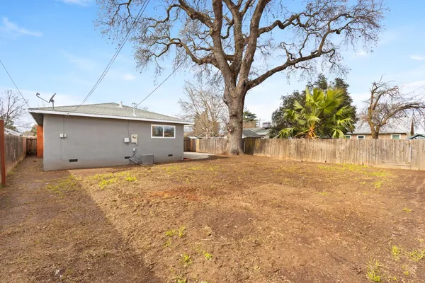 a view of a house with a yard and tree