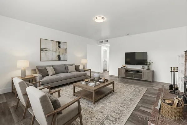 a living room with furniture a flat screen tv and a table
