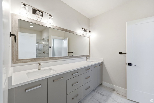 496 North Farmhouse Way, Unit 11 Midway, UT 84049 - Photo 38 of 50 Double vanity with integrated sinks, white countertops, gray cabinetry, brushed nickel hardware, and wood-finish framed mirror