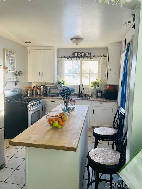 44329 3rd Street East Lancaster, CA 93535 - Photo 3 of 13 a kitchen with a table chairs stove and refrigerator