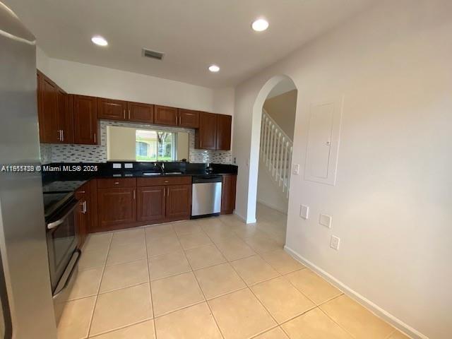 2708 Southwest 83rd Avenue, Unit 105 Miramar, FL 33025 - Photo 2 of 15 a large kitchen with stainless steel appliances granite countertop a refrigerator and a sink